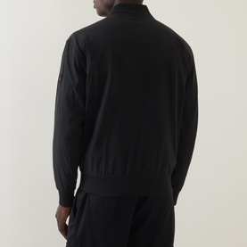 Model wearing Hugo Boss Orange black zip-through sweat, back view, with matching black joggers. Ribbed hem and cuffs visible.