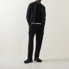 Model wearing Hugo Boss Orange black zip-through sweat in polyamide blend, styled with black trousers and chunky leather shoes.