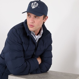 Model with Hugo Moonstruck Crest Logo Cap in dark blue, white crest logo to front, styled with navy puffer jacket