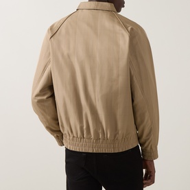 Model wearing Hugo medium beige casual jacket, rear view, ribbed elasticated hem and cuffs, styled with black trousers