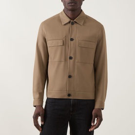 Model wearing Hugo Juliano Pocket Jacket in beige, featuring button fastening, chest patch pockets, and collared neckline, styled with black jeans.