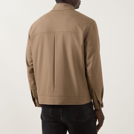 Model wearing Hugo Juliano Pocket Jacket in beige, rear view showing clean back seam and buttoned cuffs, styled with dark jeans
