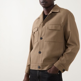 Model wearing Hugo Juliano Pocket Jacket in beige, featuring button fastening, chest pockets and collared neckline, styled with dark jeans.
