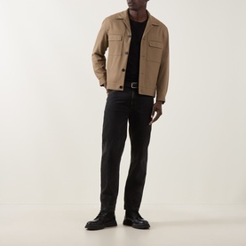 Model wearing Hugo Juliano Pocket Jacket in beige, with black T-shirt, dark jeans, and black leather shoes.