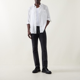 Model wearing Hugo Erillo Striped Shirt in Natural with black slim-fit trousers and black loafers.