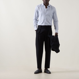 Model wearing Hugo Kenno Stripe Shirt in Open Blue with black tailored trousers and black loafers, holding dark blazer