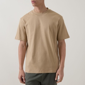 Model wearing Hugo medium beige crew neck cotton T-shirt, styled with khaki trousers