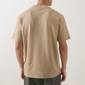 Model wearing Hugo medium beige 100% cotton crew neck T-shirt, rear view, styled with olive trousers.