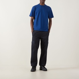 Model wearing Hugo Dapolino Logo T-Shirt in Open Blue, crew neck, short sleeves, styled with dark cargo trousers and black boots