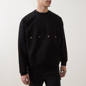Model wearing Hugo black cotton crew neck sweatshirt with spaced logo lettering across chest