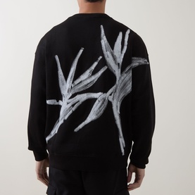 Model wearing Hugo black cotton crew neck sweatshirt, back view showing large abstract grey brushstroke graphic print.