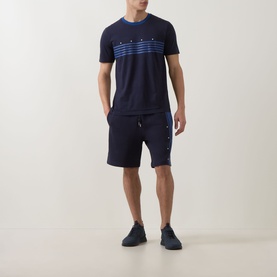 Model wearing Hugo dark blue crew neck T-shirt with stripe graphic print, styled with matching navy shorts and dark trainers