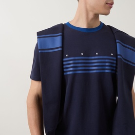 Model wearing Hugo dark blue cotton crew neck T-shirt with blue horizontal chest stripes and logo lettering, styled with matching navy jacket over