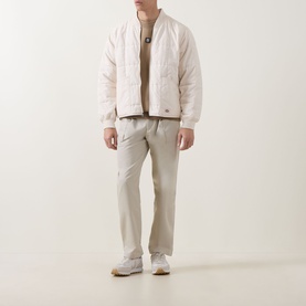 Model wearing Hugo Beige Overflow crew neck sweatshirt, styled with cream quilted jacket and light beige trousers.