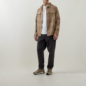 Model wearing Hugo Detzi Logo T-Shirt in Natural under a beige check overshirt, styled with dark trousers and trail trainers.