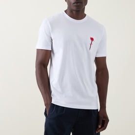 Model wearing Hugo Diflow Logo T-Shirt in white, crew neck with red floral chest graphic, styled with navy trousers