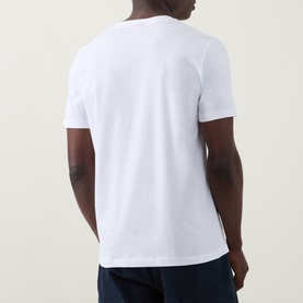 Model wearing Hugo Diflow Logo T-Shirt in white, back view, crew neck, short sleeves, paired with navy trousers.