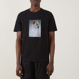 Model wearing Hugo Durose Graphic T-Shirt in black with rose photo print, crew neck, short sleeves, paired with black trousers.