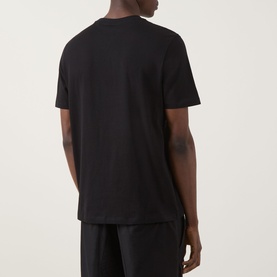 Model wearing Hugo Durose Graphic T-Shirt in black, crew neck with short sleeves and dropped shoulders, back view, styled with black trousers