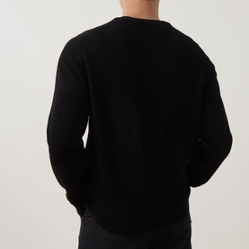 Model wearing Hugo black viscose-blend crew neck knit sweater, back view showing relaxed fit and ribbed hem detail.