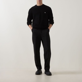 Model wearing Hugo black viscose crew neck jumper with small chest logo, styled with black trousers and dark shoes