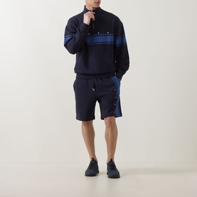 Model wearing Hugo dark blue cotton half-zip sweatshirt with stripe detail, styled with matching navy shorts and dark trainers