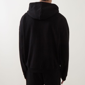 Model wearing Hugo black cotton hoodie, rear view, with matching black joggers
