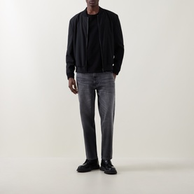 Model wearing Hugo 3049 Jeans in silver grey, styled with black zip jacket, black tee and black loafers
