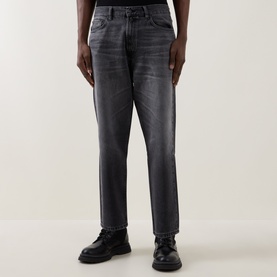 Model wearing Hugo 3049 Jeans in silver grey washed denim, straight leg fit, paired with black leather shoes