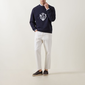 Model wearing Hugo 3049 Jeans in Natural white, styled with navy crested sweatshirt and dark espadrilles