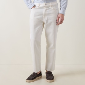 Model wearing Hugo 3049 Jeans in Natural white, straight leg, styled with a light blue shirt and dark suede loafers
