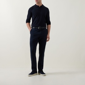 Model wearing Hugo navy knit long-sleeve polo, styled with dark chinos, black belt, and navy suede trainers.