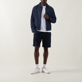 Model wearing Hugo Ejiri Denim Overshirt in Open Blue with white tee, navy shorts and white trainers.