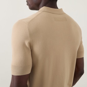 Model wearing Hugo San Peter-CV Knitted Polo Shirt in medium beige, rear view showing tonal stitching, logo detail and ribbed trims