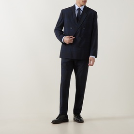 Model wearing Hugo dark blue double-breasted wool suit jacket with matching trousers, styled with a blue tie and black leather shoes