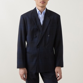 Model wearing Hugo dark blue virgin wool double-breasted suit jacket with peak lapels, styled with light blue shirt and dark trousers.