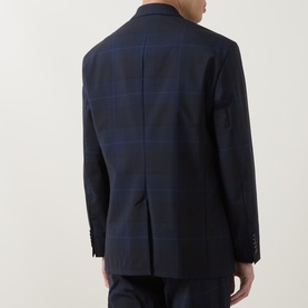 Model wearing Hugo dark blue check wool suit jacket, back view showing centre vent and notch collar detail, styled with matching trousers