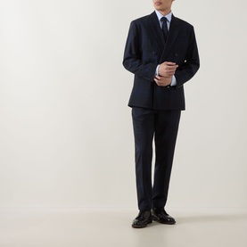Model wearing Hugo dark blue virgin wool suit jacket with matching trousers, light blue shirt and tie, styled with dark leather shoes