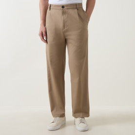 Model wearing Hugo Craysohne263 Straight Leg Trousers in beige, mid-rise with front pleats, styled with white trainers and white tee.