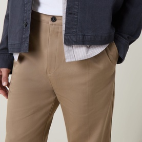 Model wearing Hugo Craysohne263 Straight Leg Trousers in beige, mid-rise with front pleats and side pockets, styled with a navy jacket.