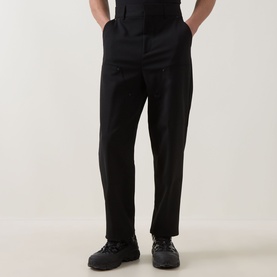 Model wearing Hugo black tailored trousers in wool-polyester blend, styled with black lace-up boots, hands in pockets