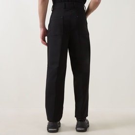 Model wearing Hugo black wide-leg trousers in polyester-wool blend, shown from behind, styled with black trainers.