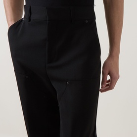 Model wearing Hugo black tailored trousers in wool-blend fabric, shown from waist to knee, side angle