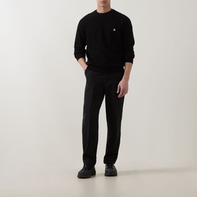 Model wearing Hugo black trousers in wool-polyester blend, styled with matching black sweatshirt and dark trainers.