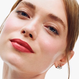 Model wearing Clinique Chubby Stick Moisturizing Lip Colour Balm in Chunky Cherry, showing a bold red lip with natural skin finish