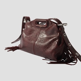 Maje dark burgundy leather crossbody bag with fringe trim, silver hardware, adjustable strap and structured M-clasp detail