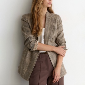 Model wearing Reiss neutral check blazer, styled with white top and brown trousers