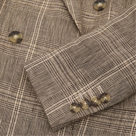 Reiss neutral check double-breasted blazer, close-up of sleeve cuff with gold buttons and Prince of Wales check fabric detail.