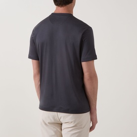 Model wearing Eleventy Girocollo Solid T-Shirt in black, rear view, crew neck, short sleeves, styled with light beige trousers.