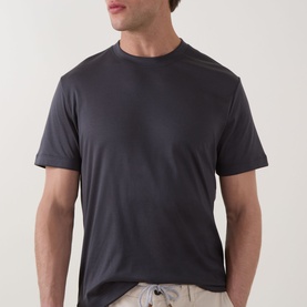 Model wearing Eleventy Girocollo Solid T-Shirt in black, crew neck, short sleeves, styled with light-coloured trousers.